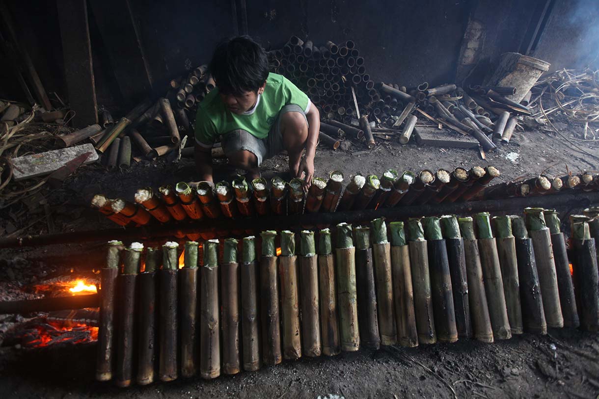 Perajin saat memasak Lamang Tapai makanan tradisional dari Minangkabau dengan kayu bakar di Kawasan Senen, Jakarta, Selasa (25/3/2025).  (Beritanasional.com/Oke Atmaja)