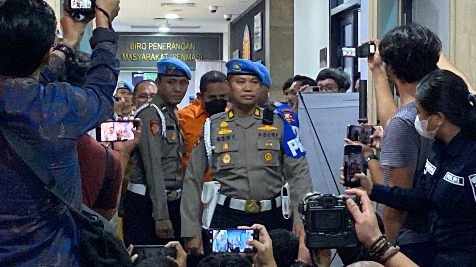 Mantan Kapolres Ngada AKBP Fajar Widyadharma Lukman Sumaatmaja saat (baju oranye) saat digelandan ke kantor polisi. (Foto/Istimewa)