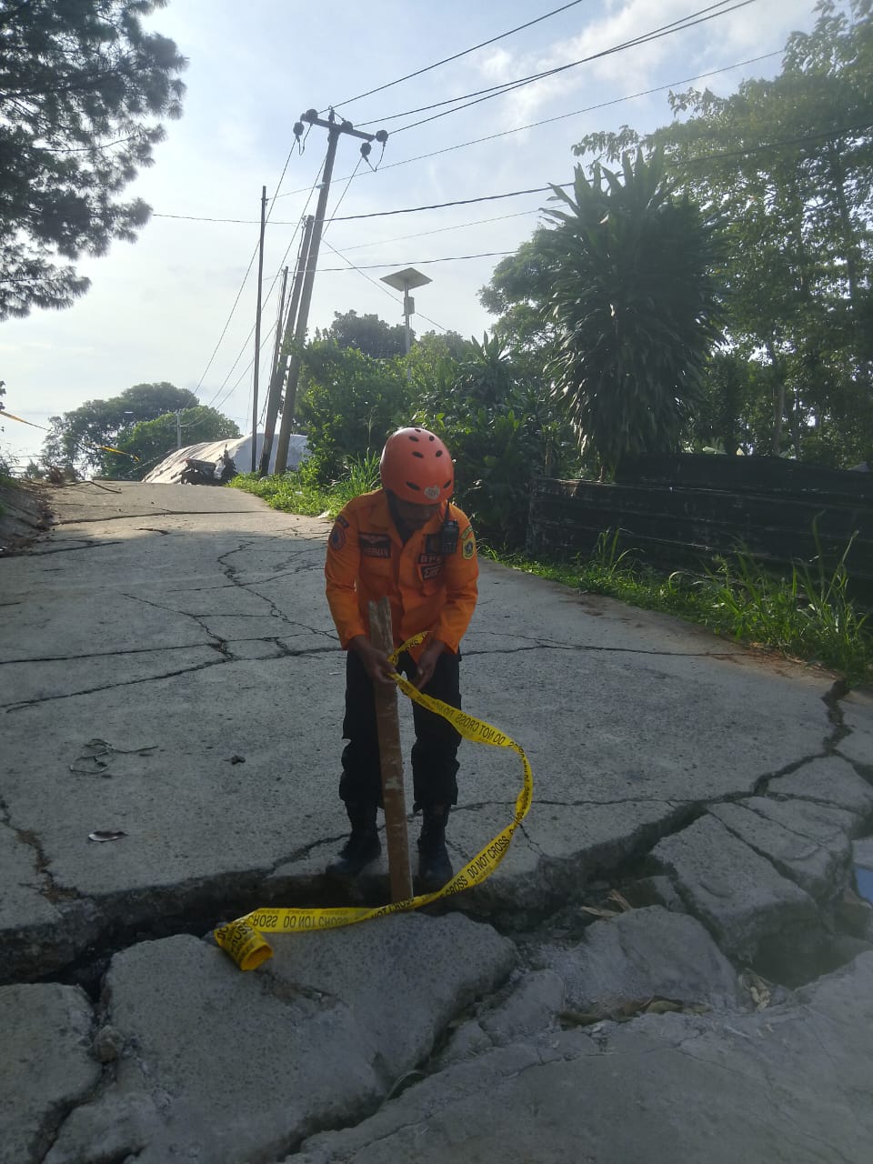 Petugas sedang memasang tali pembatas fenomena tanah bergerak di Bogor Jawa Barat. (BeritaNasional/BNPB)