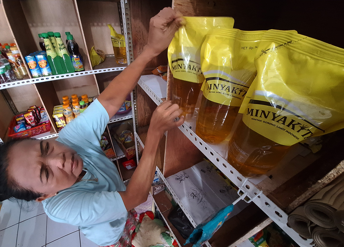 Pedagang menunjukan minyak kita di warung kelontong, Jakarta, Kamis (9/5/2024). (BeritaNasional.com/Oke Atmaja)