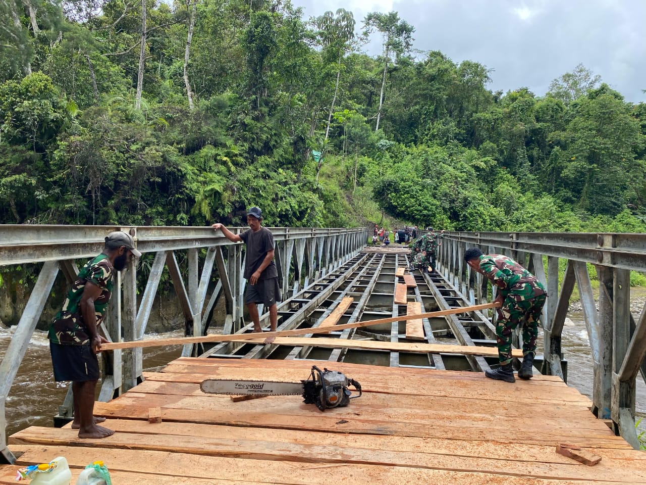 Prajurit TNI dan warga saling bertumbukan memperbaiki jembatan rusak di istrik Apalapsili, Kabupaten Yalimo, Papua. (BeritaNasional/Elvis Sendouw/HO Puspen TNI AD)