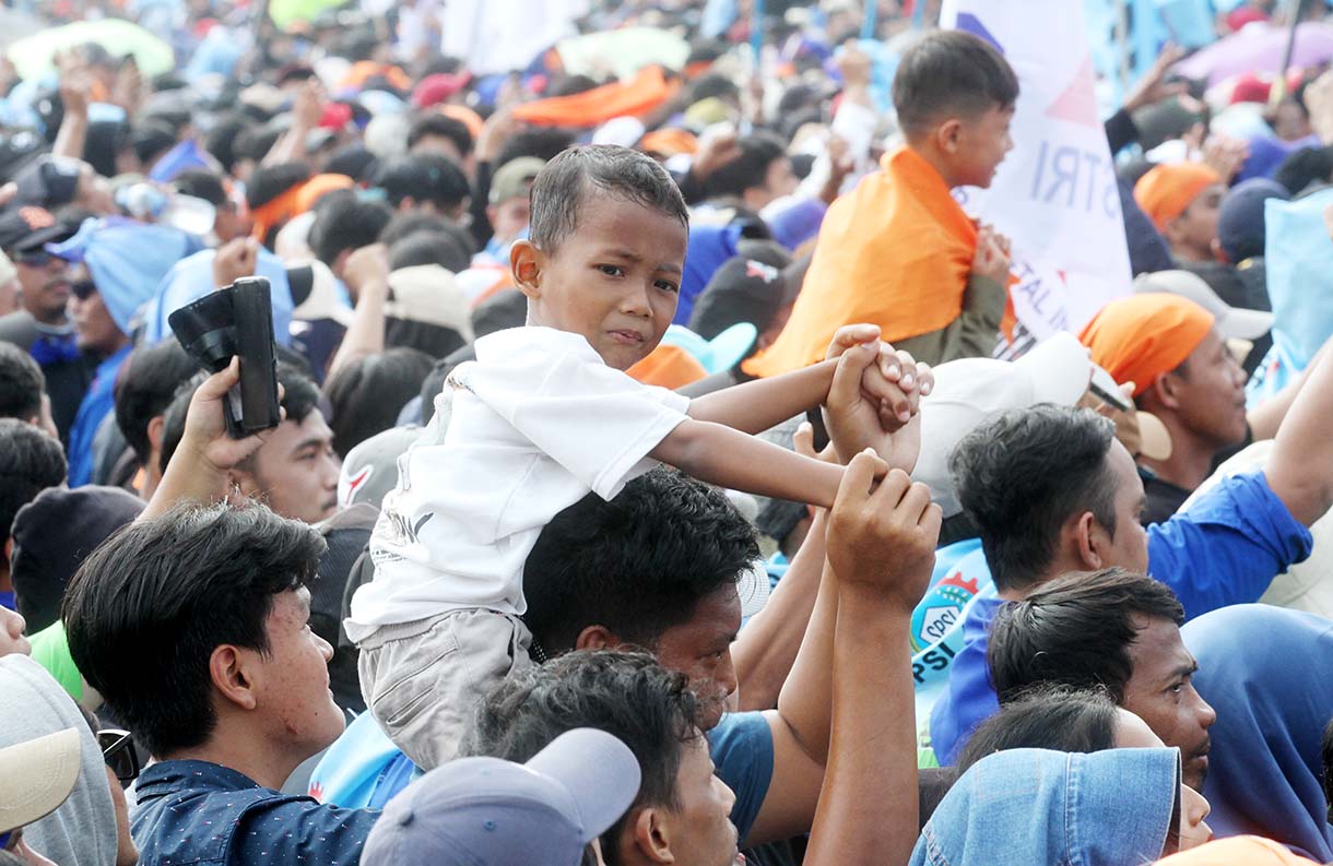 Buruh membawa anaknya saat peringati hari buruh di Lapangan Monas, Jakarta Pusat, Kamis (1/5/2025).(Beritanasional.com/Oke Atmaja)