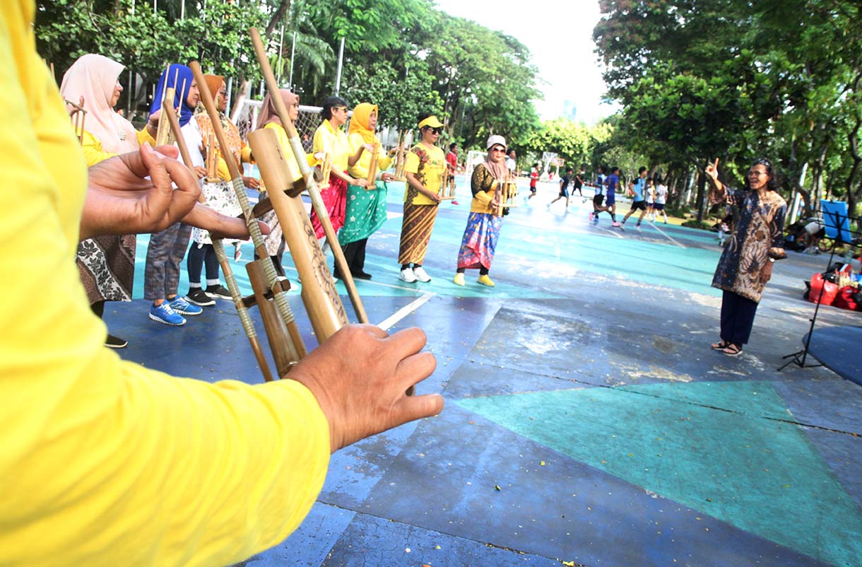 Warga memainkan alat music tradisional angklung di Taman Menteng, Jakarta, Minggu (25/5/2025). (Beritanasional.com/Oke Atmaja)