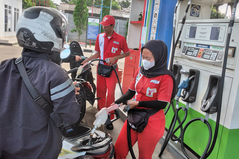 Pengendara motor saat antre mengisi bahan bakar minyak di SPBU. (BeritaNasional/Elvis Sendouw)