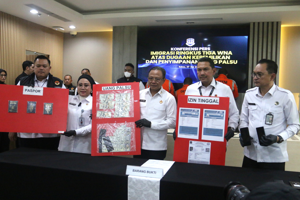 Plt. Direktur Jenderal Imigrasi Yuldi Yusman (kedua kiri), Kasubdit IV Dittipideksus Bareskrim Polri Bismo Teguh Prakoso (kedua kanan), Kepala Kantor Wilayah Ditjen Imigrasi Daerah Khusus Jakarta Pamuji Raharja (kanan) dan Kepala Kantor Imigrasi Jakarta Barat Nur Raisha Pujiastuti (kiri) menunjukan barang bukti saat pengungkapan tiga WNA atas dugaan kepemilikan dan penyimpanan uang palsu di Kantor Dijen Imigrasi,  Jakarta, Selasa (27/5/2025). (Berita nasional.com/Oke Atmaja)