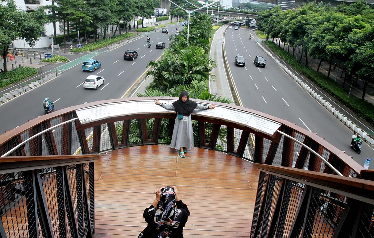 Warga berfoto di Jembatan Penyeberangan Orang (JPO) 'Kapal Pinisi' di jalan Jenderal Sudirman, Jakarta, Senin (12/5/2025). (Beritanasional.com/Oke Atmaja)