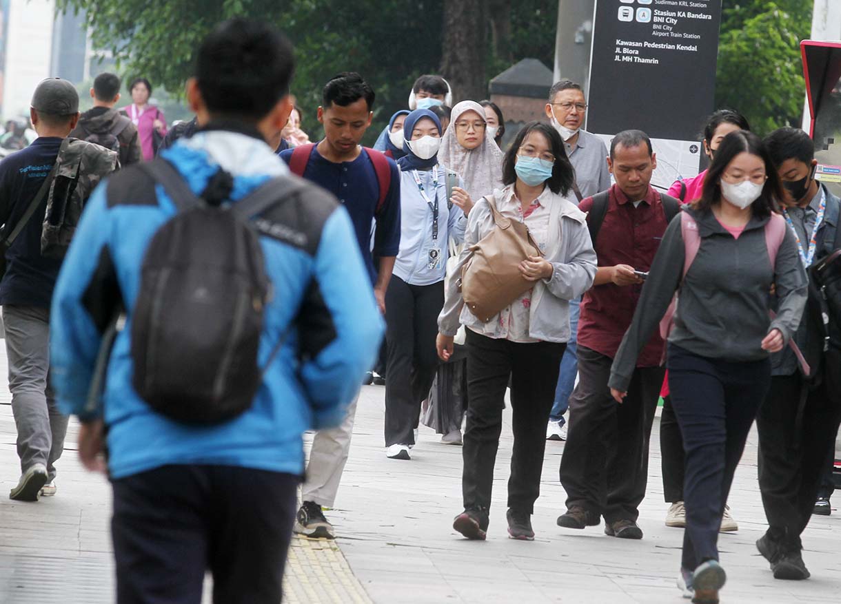 Pekerja melintas di Jalan Jenderal Sudirman, Jakarta Pusat, Rabu (14/5/2025). (Beritanasional.com/Oke Atmaja)