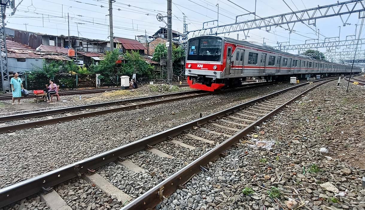 Warga menyeberang rel kereta api di Kawasan Stasiun Manggarai, Jakarta, Minggu(4/5/2025).  (Beritanasional.com/Oke Atmaja)