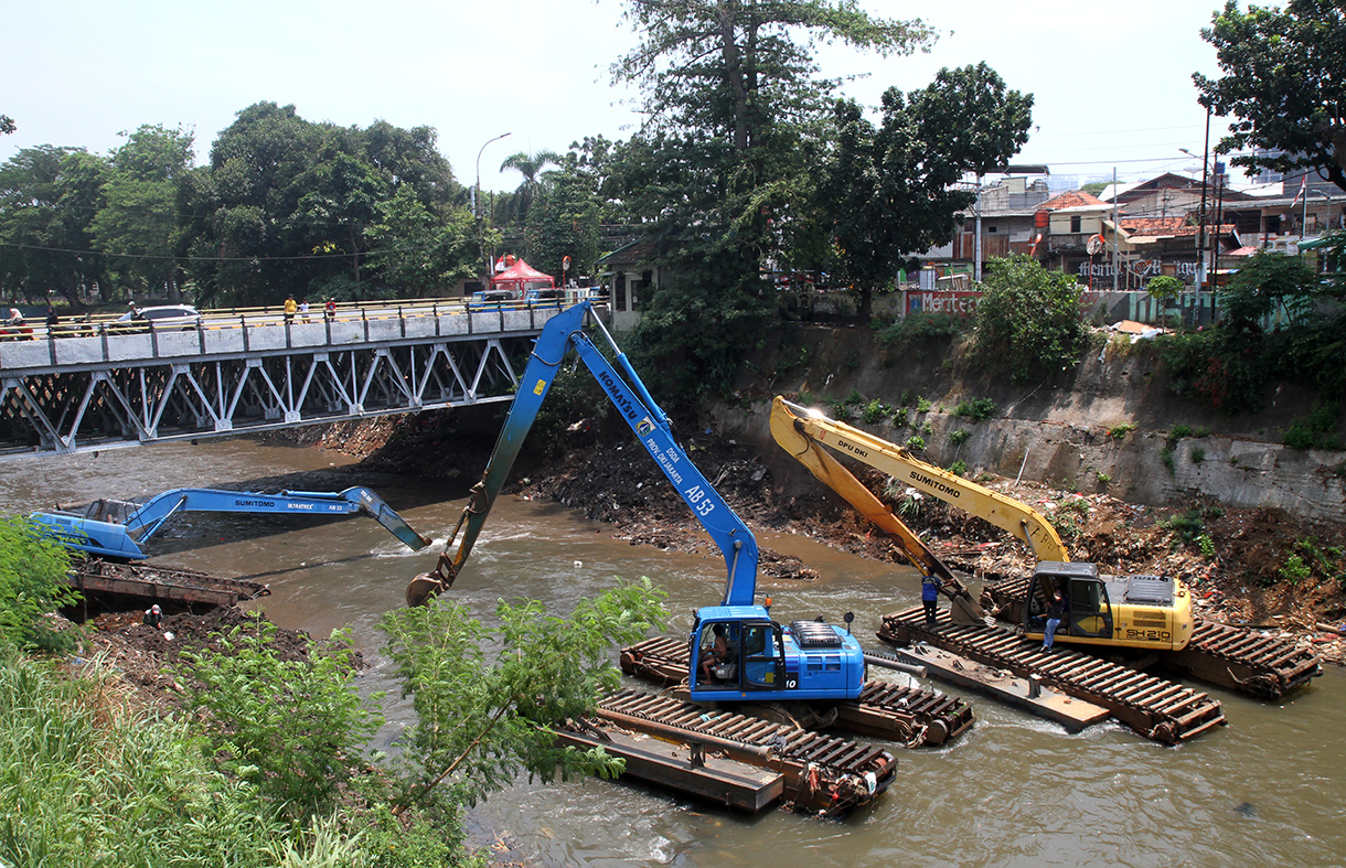 Pekerja menggunakan ekskavator mengeruk lumpur endapan Kali Ciliwung di Bidara Cina, Jakarta, Minggu(15/9/2024). (BeritaNasional.com/ Oke Atmaja)
