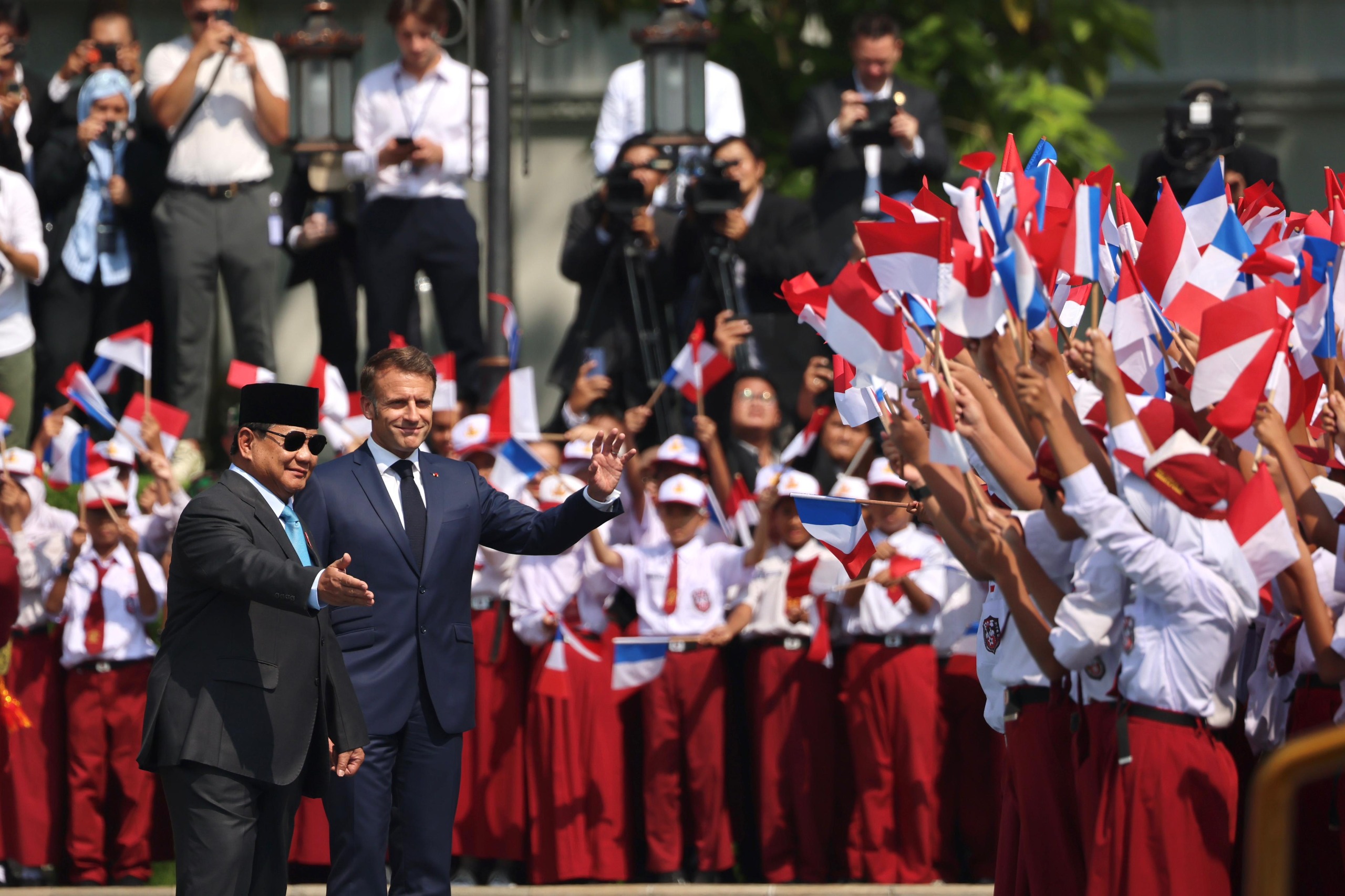 Presiden Prabowo Subianto dan Presiden Prancis Emmanuel Macron menyapa anak-anak sekolah dasar di istana Merdeka. (BeritaNasional/dok Gerindra)
