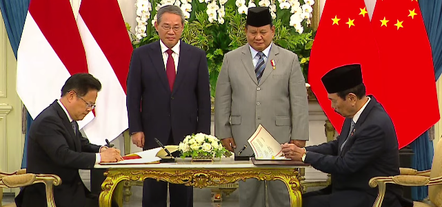 Presiden Indonesia Prabowo Subianto (berdiri, kanan) menyaksikan penandatanganan kerja sama dengan China di bidang maritim. (Foto/YouTube Setpres)