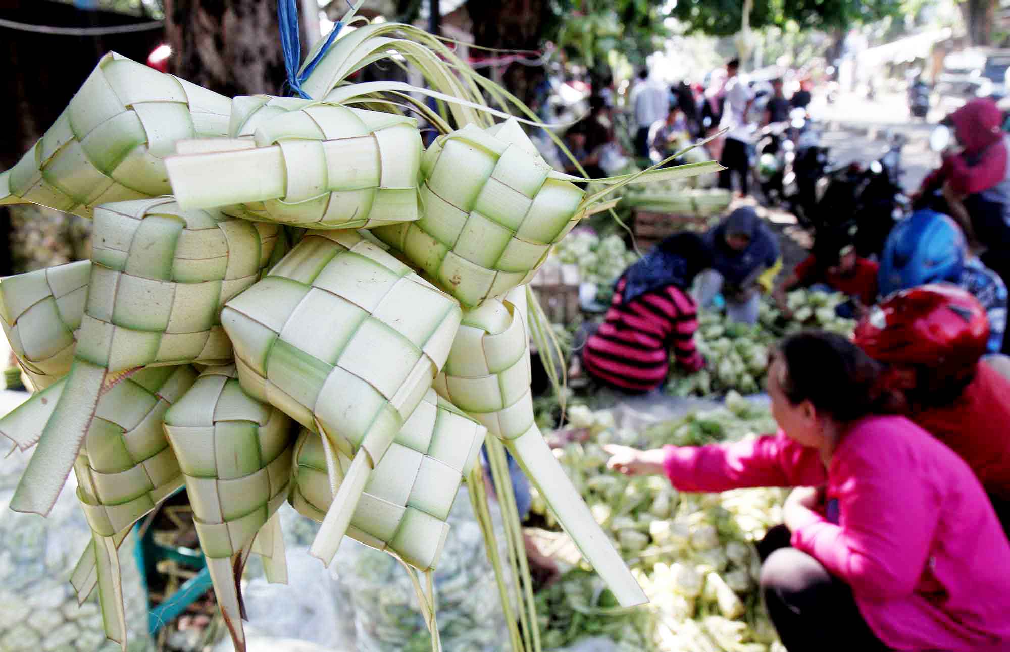 Pembeli memilih bungkus ketupat di Pasar Palmerah, Jakarta, Kamis (5/6/2025).  (Beritanasional.com/Oke Atmaja)