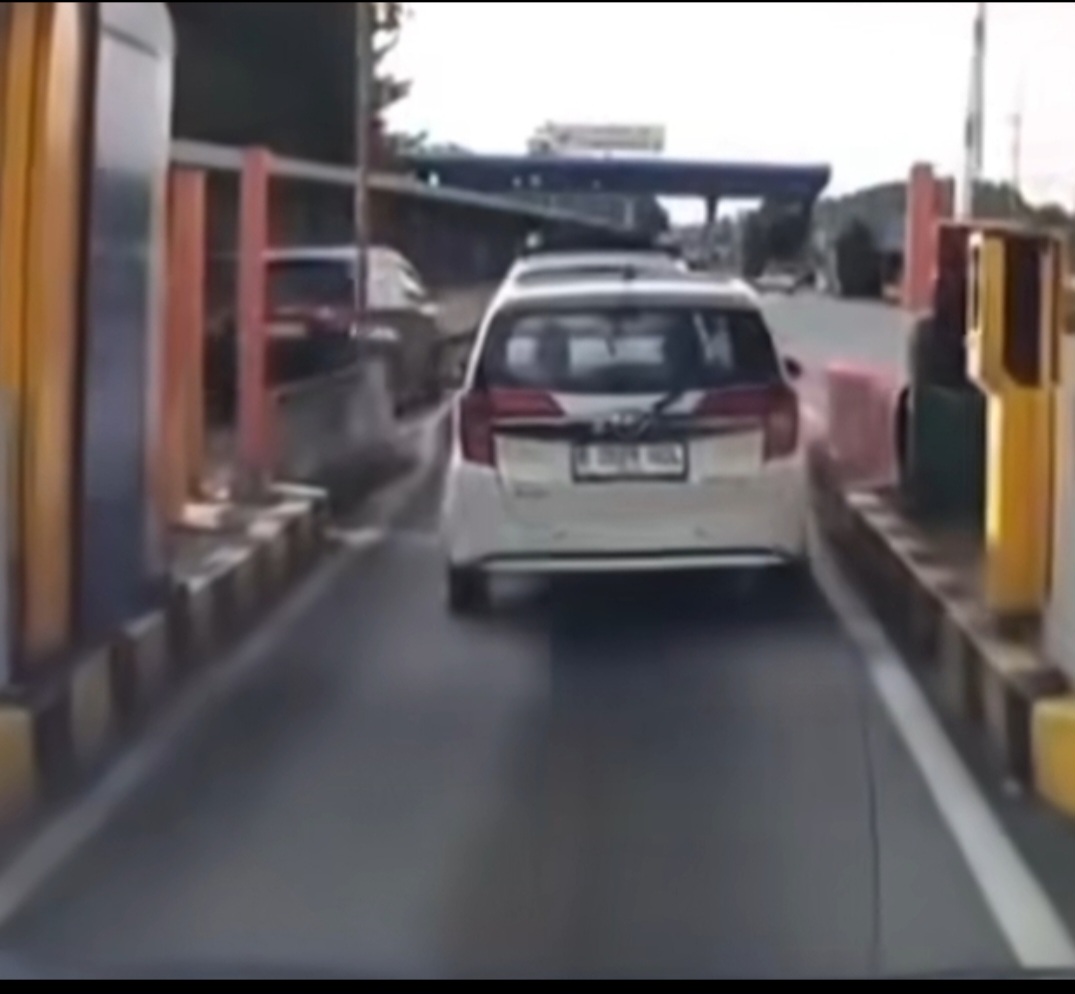 Mobil putih menerobos palang tol. (BeritaNasional/tangkapan layar)