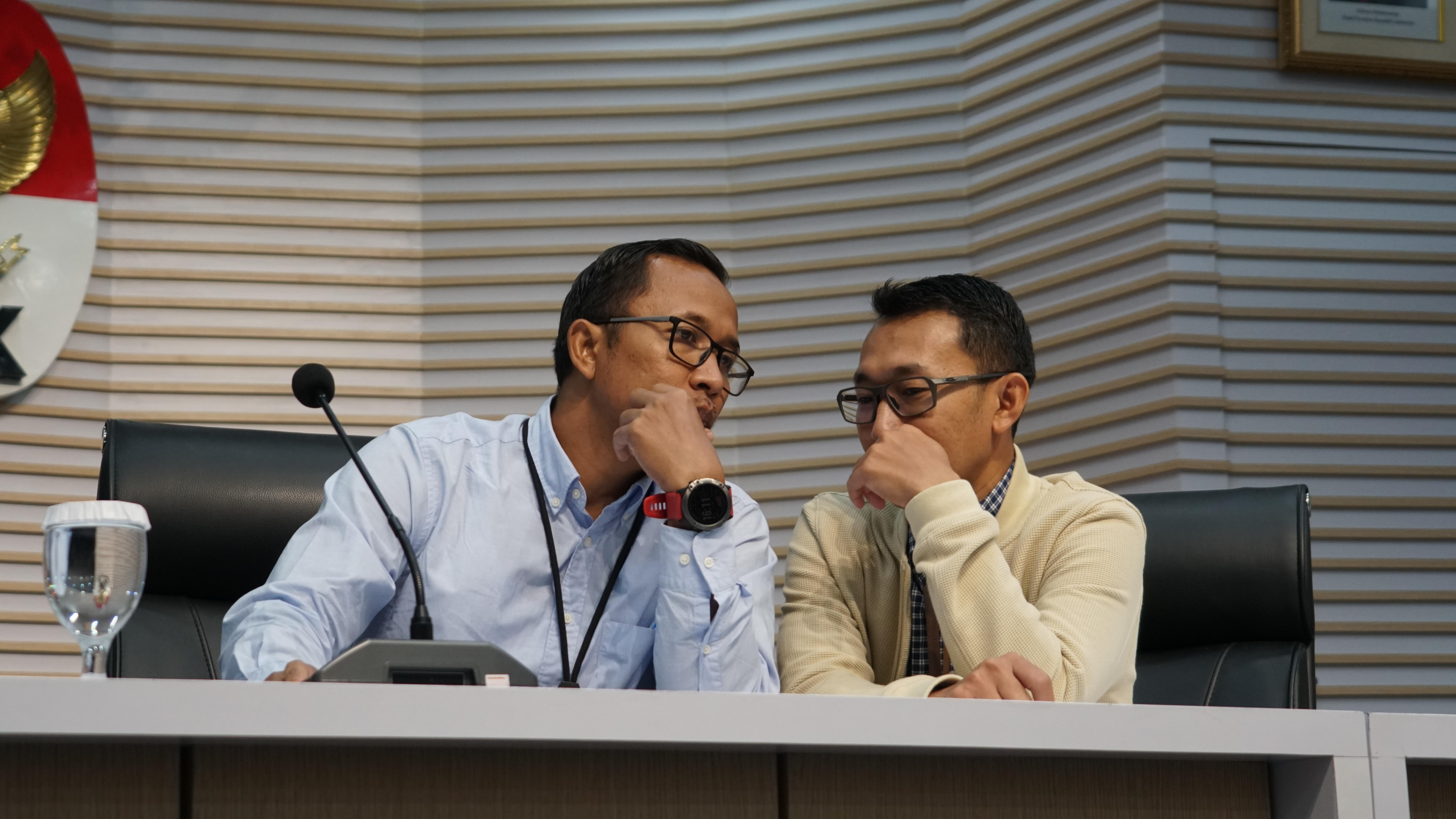 Plh Direktur Penyidikan KPK Budi Sokmo Wibowo (kiri) berbicara kecil dengan Jubir Budi Prasetyo. (Foto/Dokumentasi KPK)