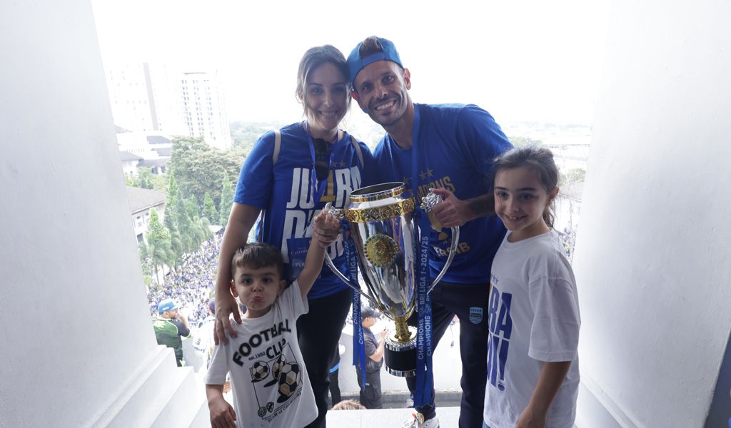 Tyronne Del Pino mengangkat trofil Liga 1 bersama istri dan anaknya. (Foto/persib.co.id)