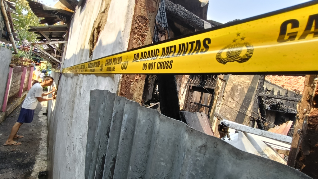 Warga melihat rumah yang terbakar di Jalan Kutilang, Bukit Duri, Tebet, Jakarta Selatan, Sabtu (19/7/2025). (Beritanasional.com/ Oke Atmaja)