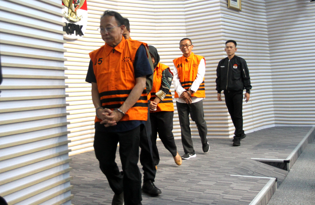 Empat tersangka dugaan pemerasan dalam pengurusan Rencana Penggunaan Tenaga Kerja Asing (RPTKA) di lingkungan Kementerian Ketenagakerjaan, mantan Direktur Pengendalian Penggunaan TKA Kemenaker Wisnu Pramono (kiri), mantan Dirjen Binapenta dan PKK Kemenaker Haryanto (kedua kiri), mantan Direktur PPTKA Kemenaker Devi Anggraeni (kedua kanan), dan mantan Direktur Jenderal Pembinaan Penempatan Tenaga Kerja dan Perluasan Kesempatan Kerja Kemenaker Suhartono (kanan) berdiri dalam konferensi pers penahanan mereka di Gedung Merah Putih KPK, Jakarta, Kamis (17/7/2025). (Beritanasional.com/ Oke Atmaja)