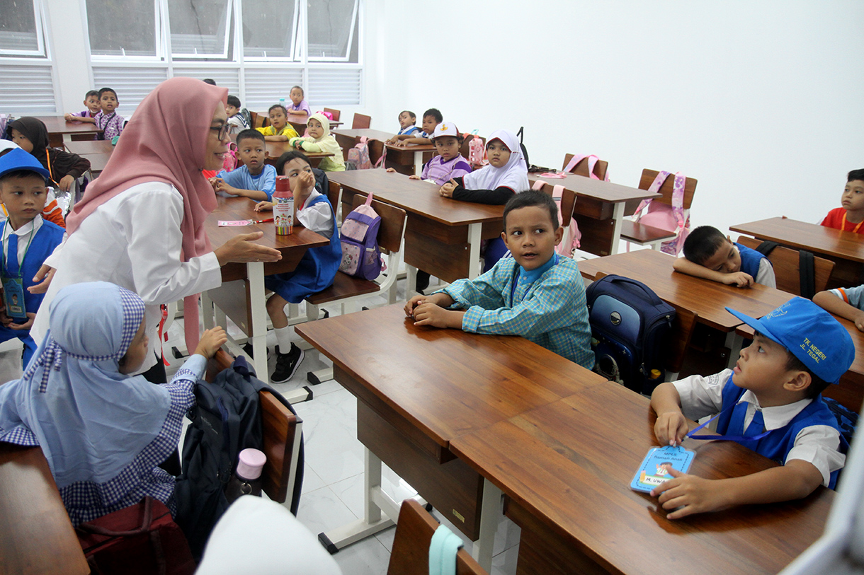 Seorang guru memberikan arahan kepada siswa baru saat mengikuti Masa Pengenalan Lingkungan Sekolah (MPLS) pada hari pertama masuk sekolah tahun ajaran 2025-2026 di SD Negeri 01/02 Cikini, Jakarta, Senin (14/7/2025).  (Beritanasional.com/Oke Atmaja)