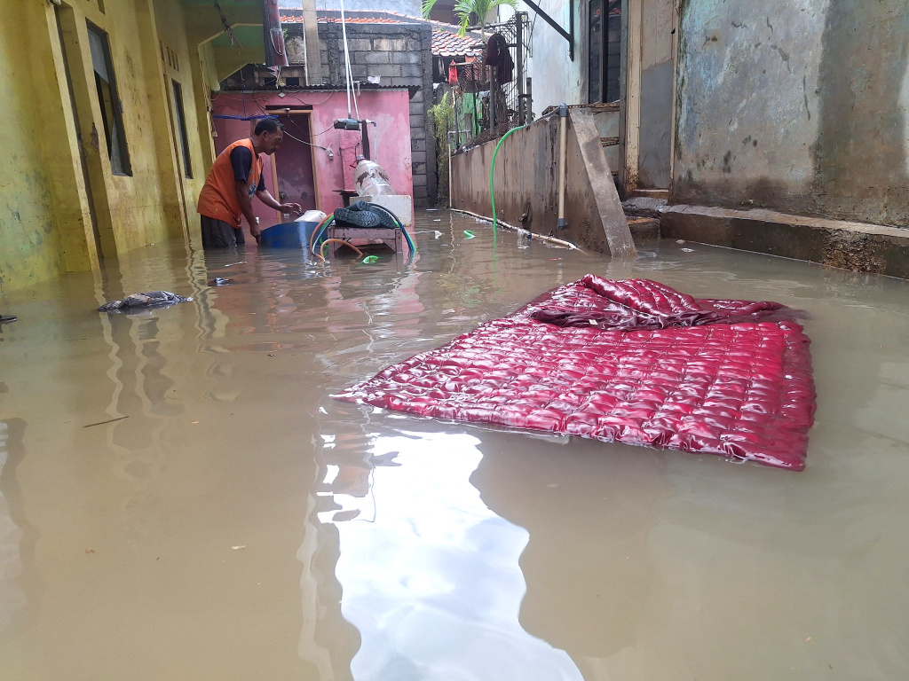 Warga beraktivitas saat banjir setinggi 60 Cm di Rt 16 Rw 06, Kawasan Bantaran Kali Ciliwung, Pejaten Timur, Pasar Minggu, Jakarta Selatan, Selasa (8/7/2025).   (Beritanasional.com/Oke Atmaja)