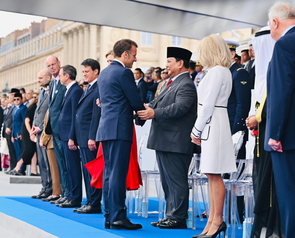Presiden Prabowo Subianto (kedua kanan) berjabat tangan dengan Presiden Prancis Emmanuel Macron (ketiga kanan) disaksikan istri Brigitte Macron (kanan) saat meghadiri parade Bastille Day di jalan Champs-Elysees, Paris, Prancis, Senin (14/7/2025). (Beritanasional.com/Biropers)