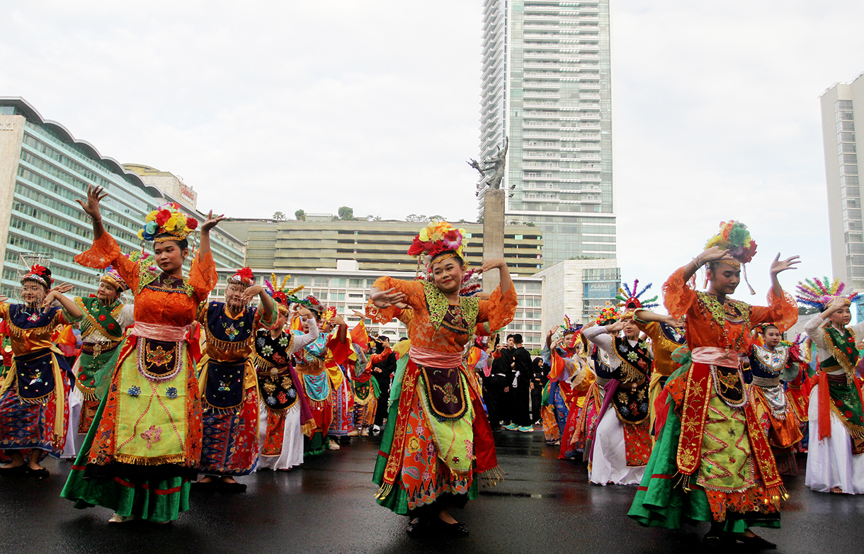 Para penari tampil mebawakan tarian Topeng Betawi saat Hari Bebas Kendaraan Bermotor (HBKB) di Kawasan Bundaran HI, Jakarta, Minggu (6 Juli 2025).  (Beritanasional.com/Oke Atmaja)