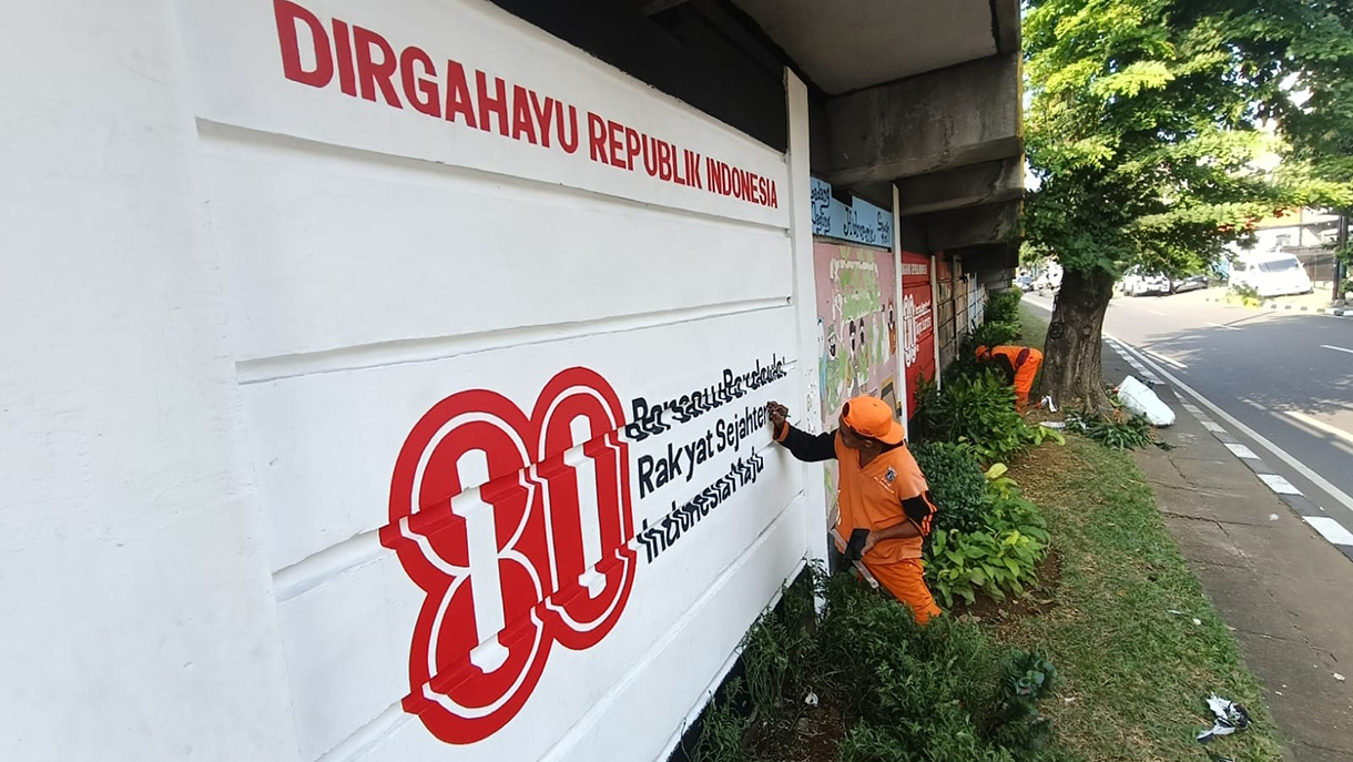 Petugas Penanganan Prasarana dan Sarana Umum (PPSU) Kelurahan Balimester, Jatinegara, membuat mural Hari Ulang Tahun (HUT) ke-80 Republik Indonesia di Kolong Fly Over Kampung Melayu, Jakarta Timur,Rabu (30/7/2025).  (Beritanasional.com/Oke Atmaja)