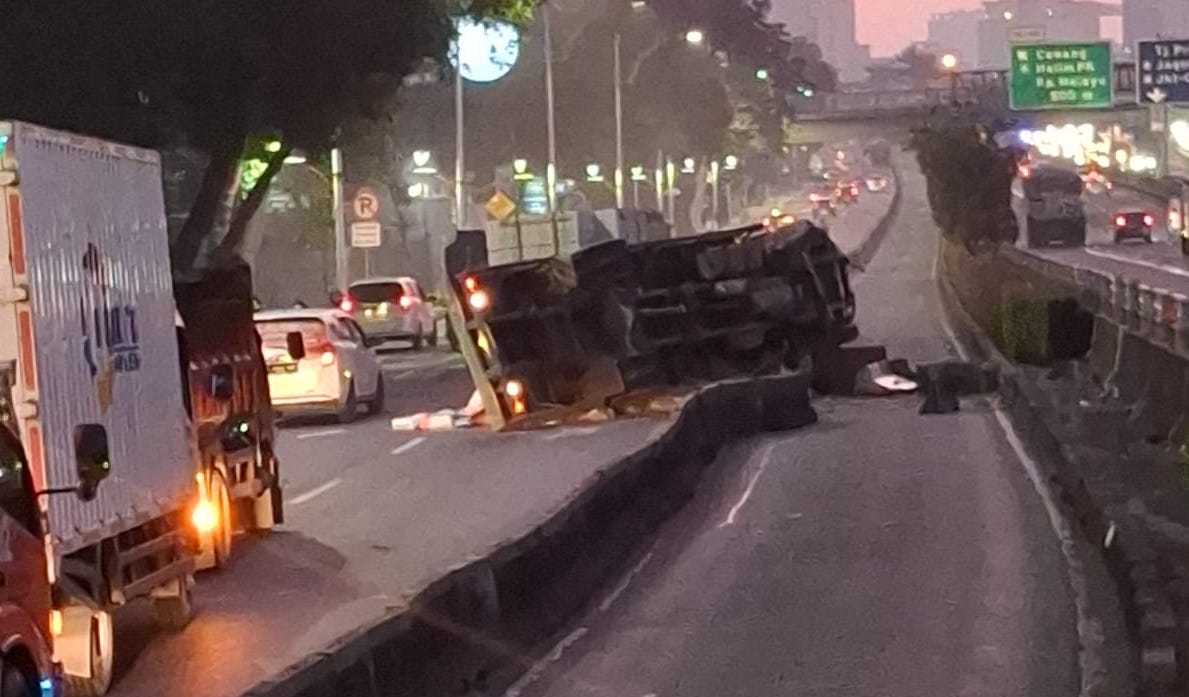 Sebuah truk terguling. (Foto/Transjakarta)