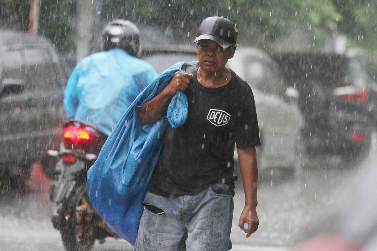 Warga melintas saat hujan di Jalan Minang Kabau, Jakarta, Selasa (12/8/2025).(Beritanasional.com/Oke Atmaja)
