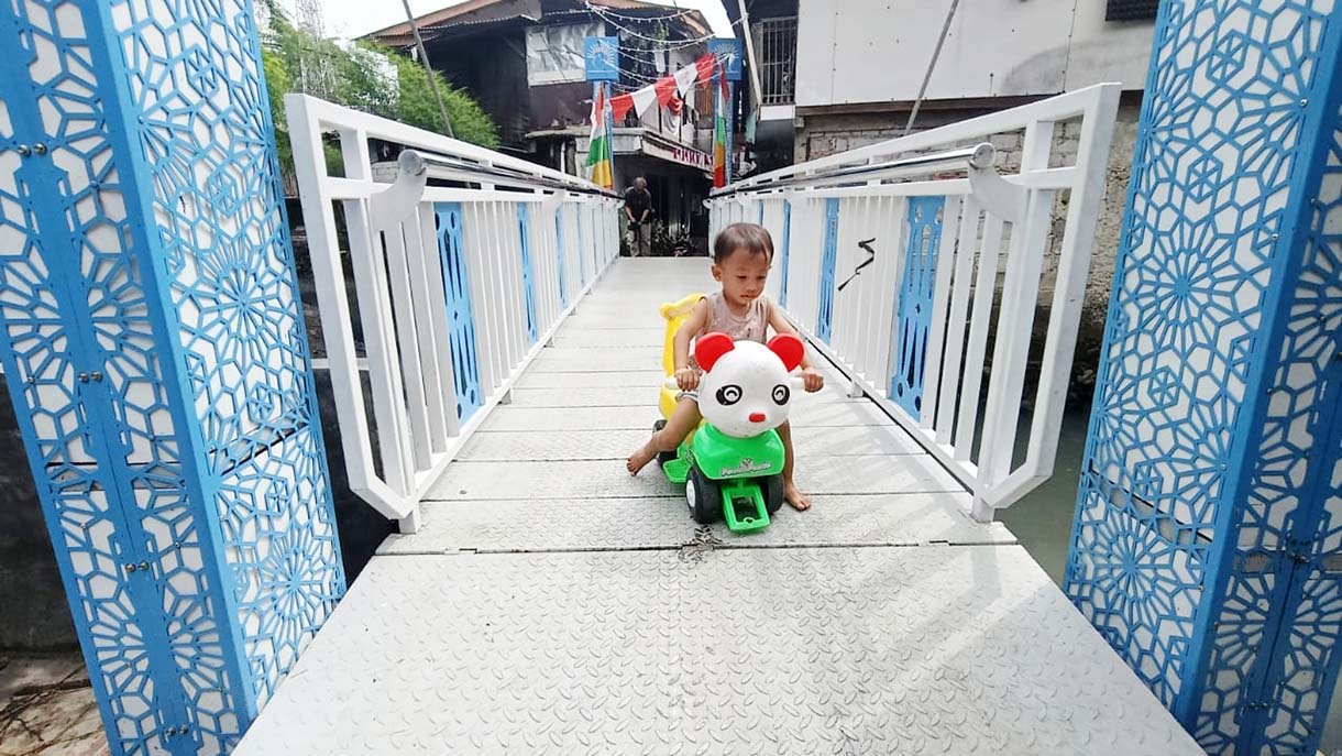 Warga melintas di Jembatan Antar Kampung (JAK) Angkat Mulia, Gandaria, Jakarta, Selasa(19/8/2025).  (Beritanasional.com/Oke Atmaja)