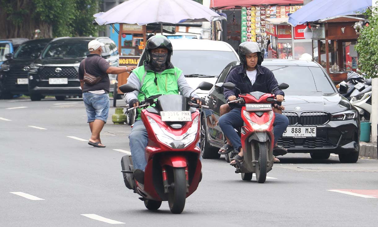 Pengemudi ojek online (ojol) mengangkut penumpang dan melintas di kawasan Stasiun Cikini, Jakarta, Sabtu (20/9/2025).  (Beritanasional.com/Oke Atmaja)