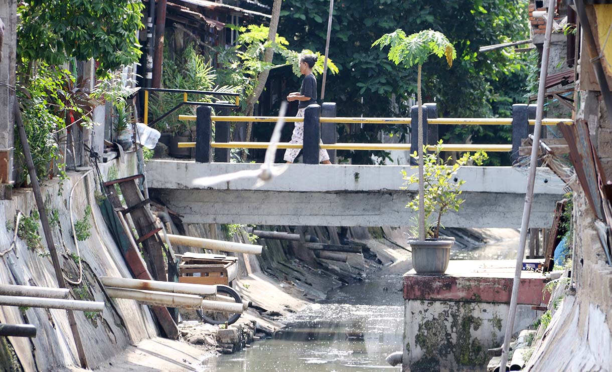 Warga melintas di jembatan kali ciliwung, Menteng, Jakarta, Rabu (10/9/2025).  (Beritanasional.com/Oke Atmaja)