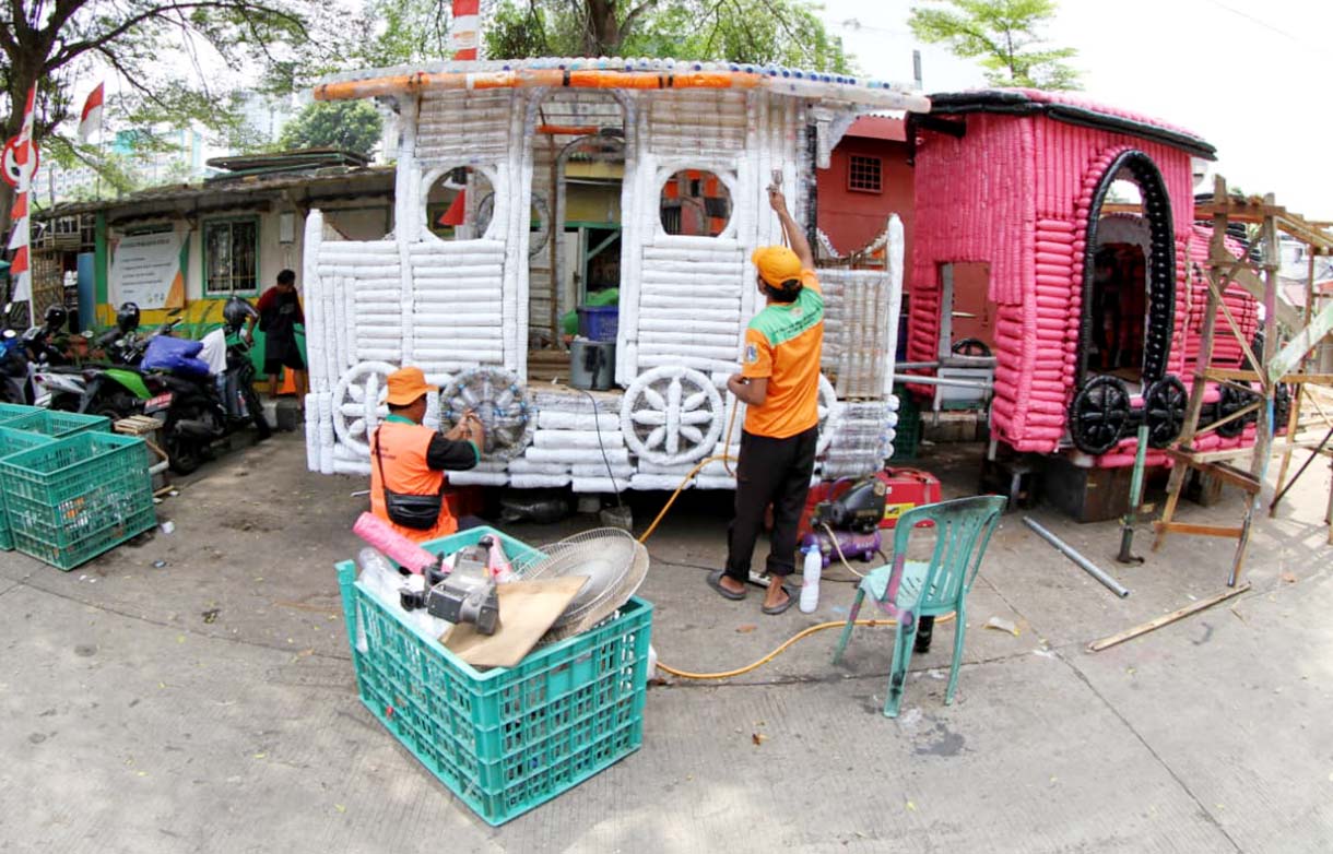 Petugas Unit Penanganan Sampah (UPS) Badan Air Dinas Lingkungan Hidup DKI Jakarta Kecamatan Senen menyelesaikan pembuatan perahu dari limbah botol plastik di Jalan Habib Ali Kwitang, Kwitang,Jakarta, Rabu (10/9/2025).  (Beritanasional.com/Oke Atmaja)