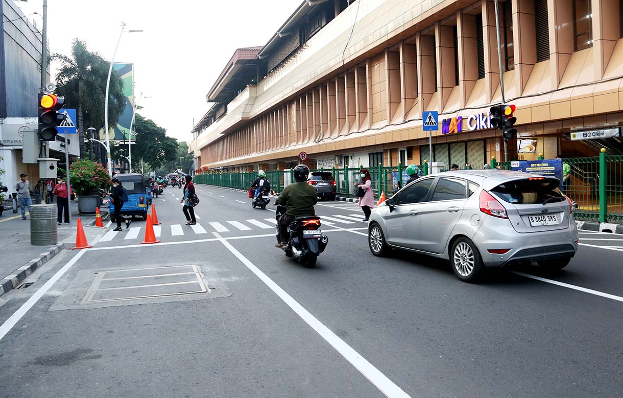 Warga menyeberang jalan menggunakan pelican crossing di sisi timur Stasiun Cikini, Jakarta, Senin (29/9/2025). (Beritanasional.com/Oke Atmaja)