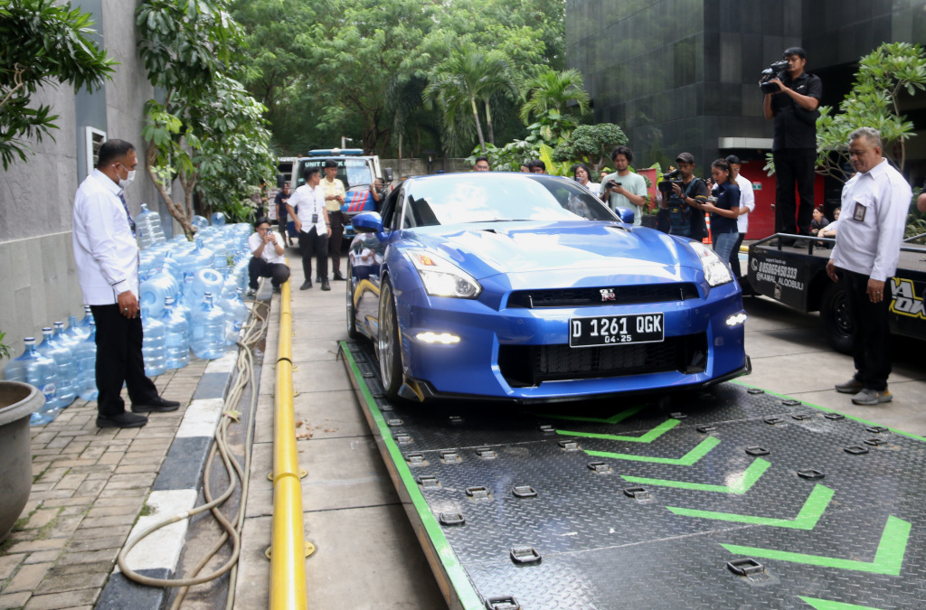 Petugas memindahkan barang sitaan sebuah kendaraan roda empat terkait kasus pemerasan K3 di Kementerian Ketenagakerjaan (Kemnaker) ke mobil derek atau towing di kawasan Gedung Merah Putih KPK, Kuningan, Jakarta Selatan, Rabu (1/10/2025). (Beritanasional.com/Oke Atmaja)