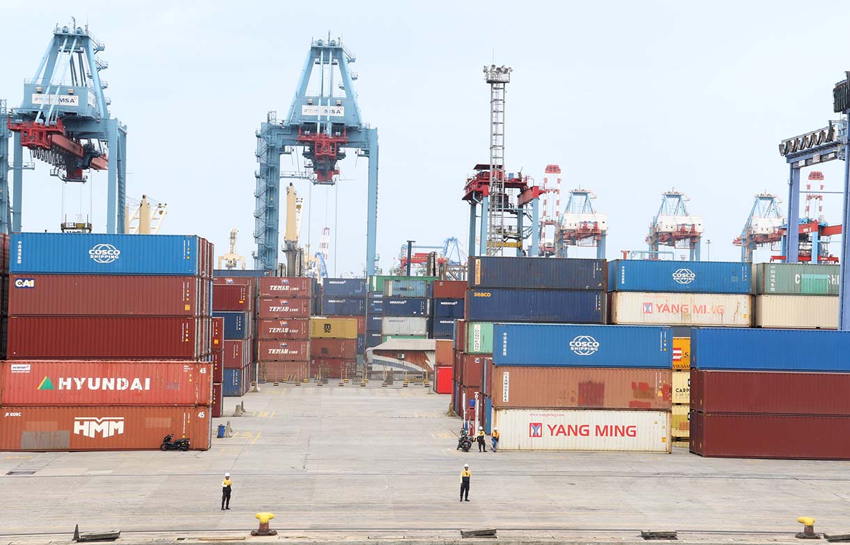 Petugas berjaga di samping peti kemas di Pelabuhan Tanjung Priok, Jakarta, Jumat (3/10/2025).  (Beritanasional.com/Oke Atmaja)