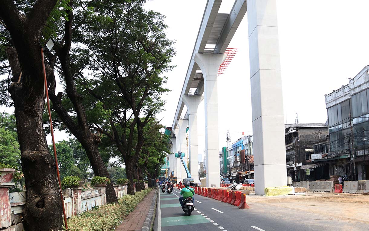 Kendaraan melintas disamping proyek pembangunan Light Rail Transit (LRT) Jakarta Fase 1B yang menghubungkan Velodrome ke Manggarai, di Jalan Tambak, Manggarai, Jakarta, Selasa (21/10/2025).(Beritanasional.com/Okeatmaja)