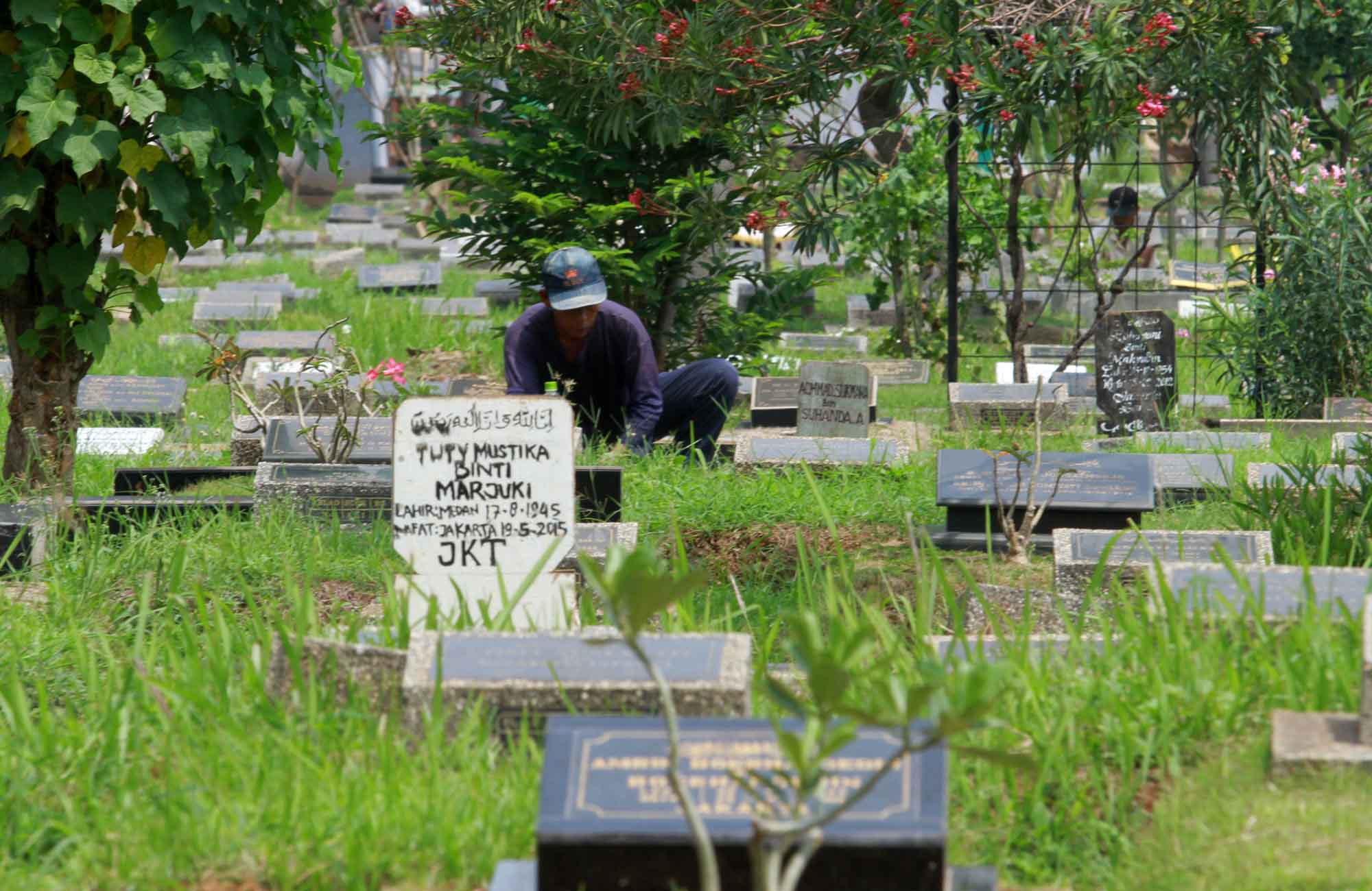 Petugas pemakaman membersihkan TPU Karet Bivak Jakarta Pusat. (BeritaNasional.com/Oke Atmaja)