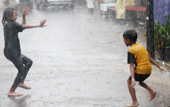 Anak-anak bermain air hujan di Jabodabek. (BeritaNasional/Oke Atmaja)