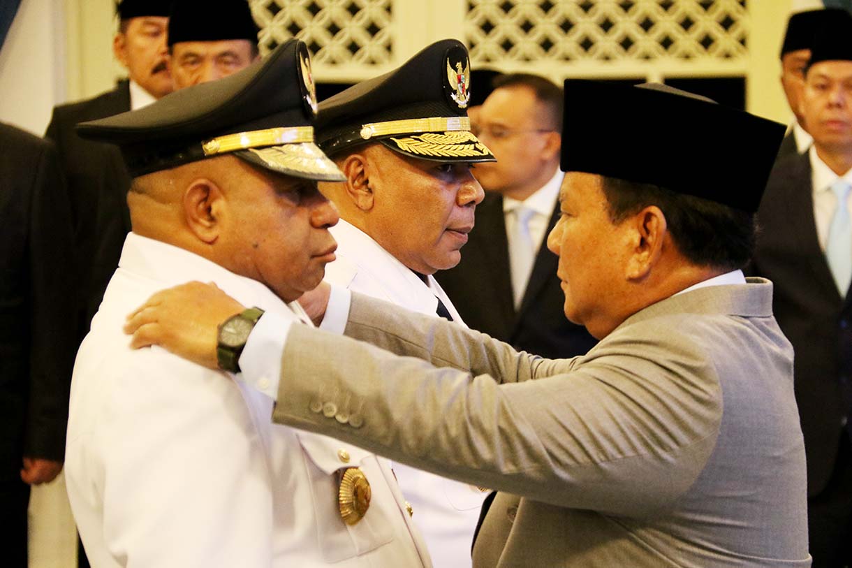 Presiden Prabowo Subianto (kanan) memasang tanda jabatan kepada Gubernur Papua Mathius Fakhiri (kiri) disaksikaan Wakil Gubernur Aryoko Rumaropen (kedua kiri) saat acara pelantikan di Istana Negara, Jakarta, Rabu (8/10/2025).  (Beritanasional.com/Oke Atmaja)