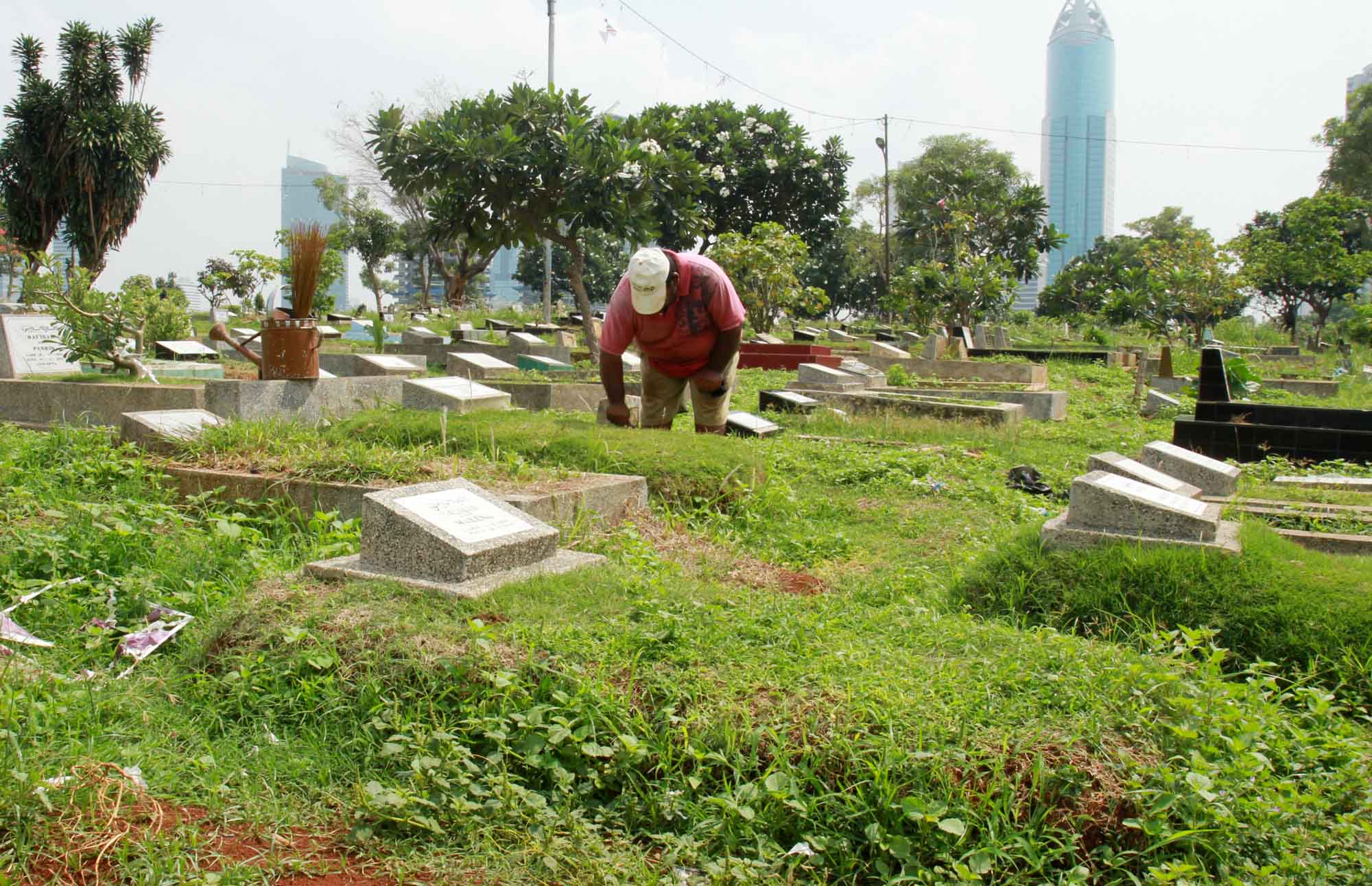 Petugas pemakaman membersihkan makam dan di Tempat Pemakaman Umum (TPU) Karet Bivak, Tanah Abang, Jakarta. (BeritaNasional/Oke Atmaja)