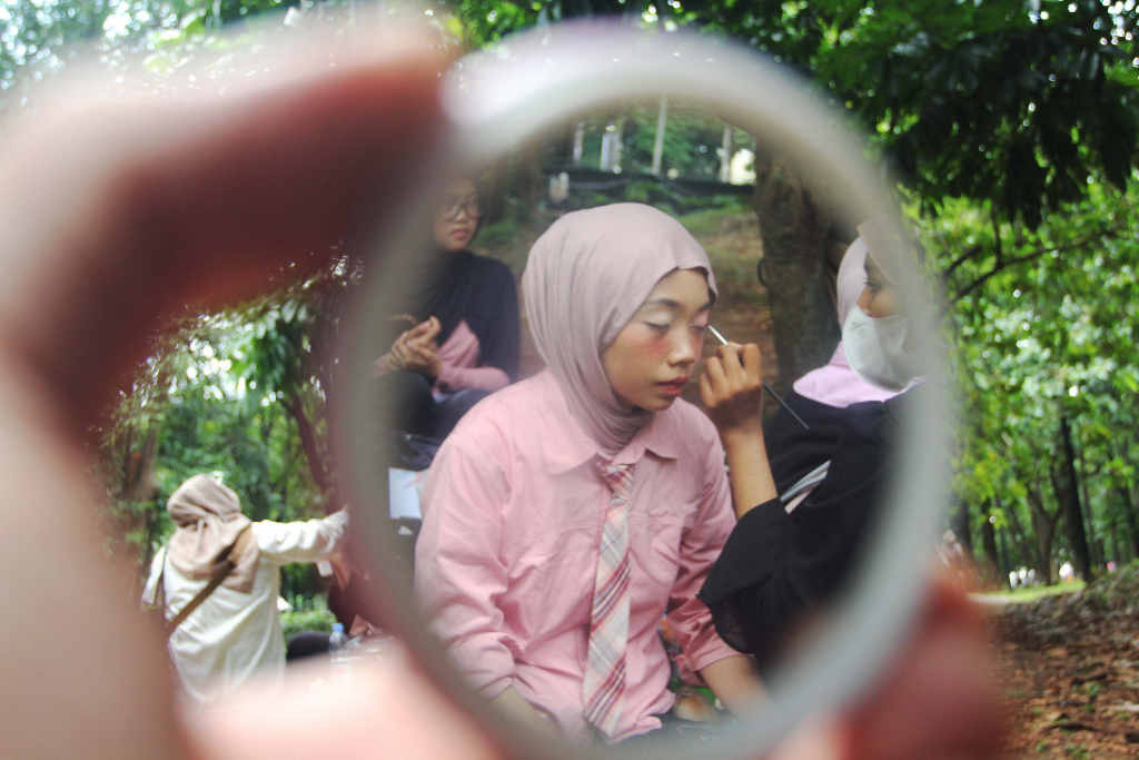 Mahasiswa melayani jasa rias wajah untuk penggemar Black Pink sebelum konser di Stadion Utama Gelora Bung Karno (SUGBK), Jakarta, Sabtu (01/11/2025). (Beritanasional.com/Oke Atmaja)