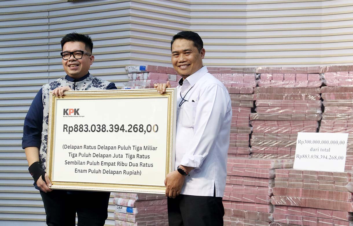 Plt Deputi Penindakan dan Eksekusi KPK, Asep Guntur Rahayu kanan menyerahkan secara simbolis uang rampasan kasus korupsi Taspen senilai Rp 883 Miliar kepada Direktur Utama PT Taspen, Rony Hanityo Aprianto di Gedung Merah Putih, KPK, Kuningan, Jakarta, Kamis (20/11/2025).  (Beritanasional.com/Oke Atmaja)