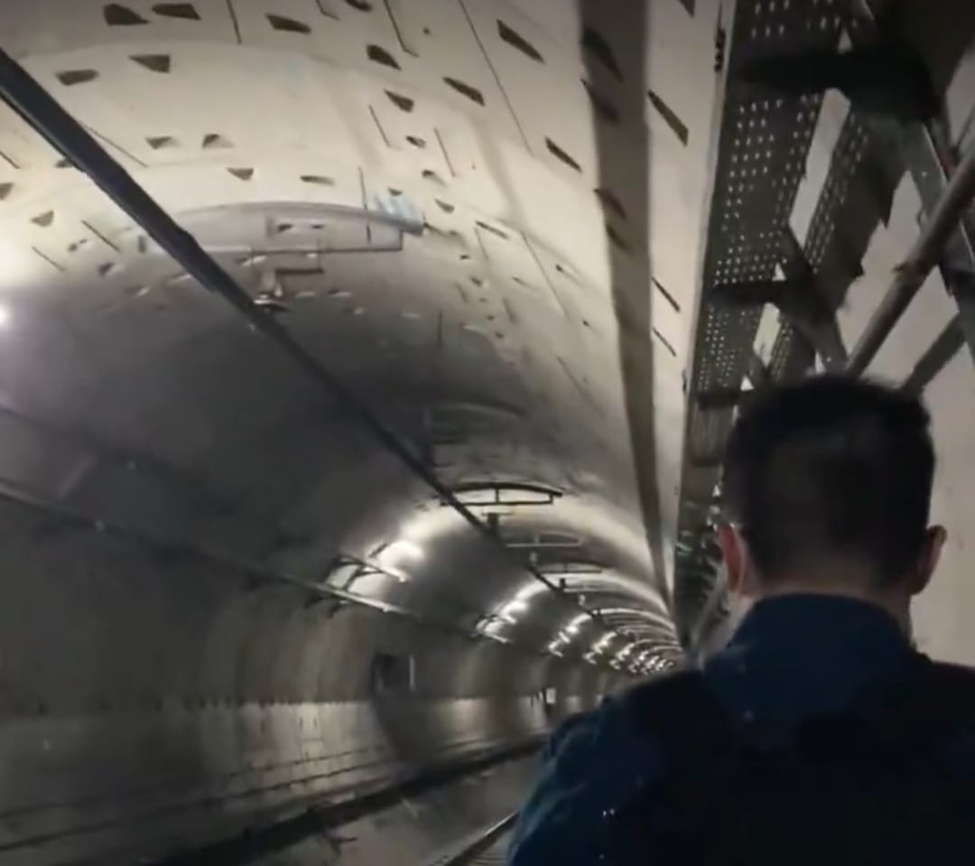 Seorang penumpang MRT berjalan di trowongagn MRT setelah MRT mengalami gangguan teknis. (BeritaNasional/X)