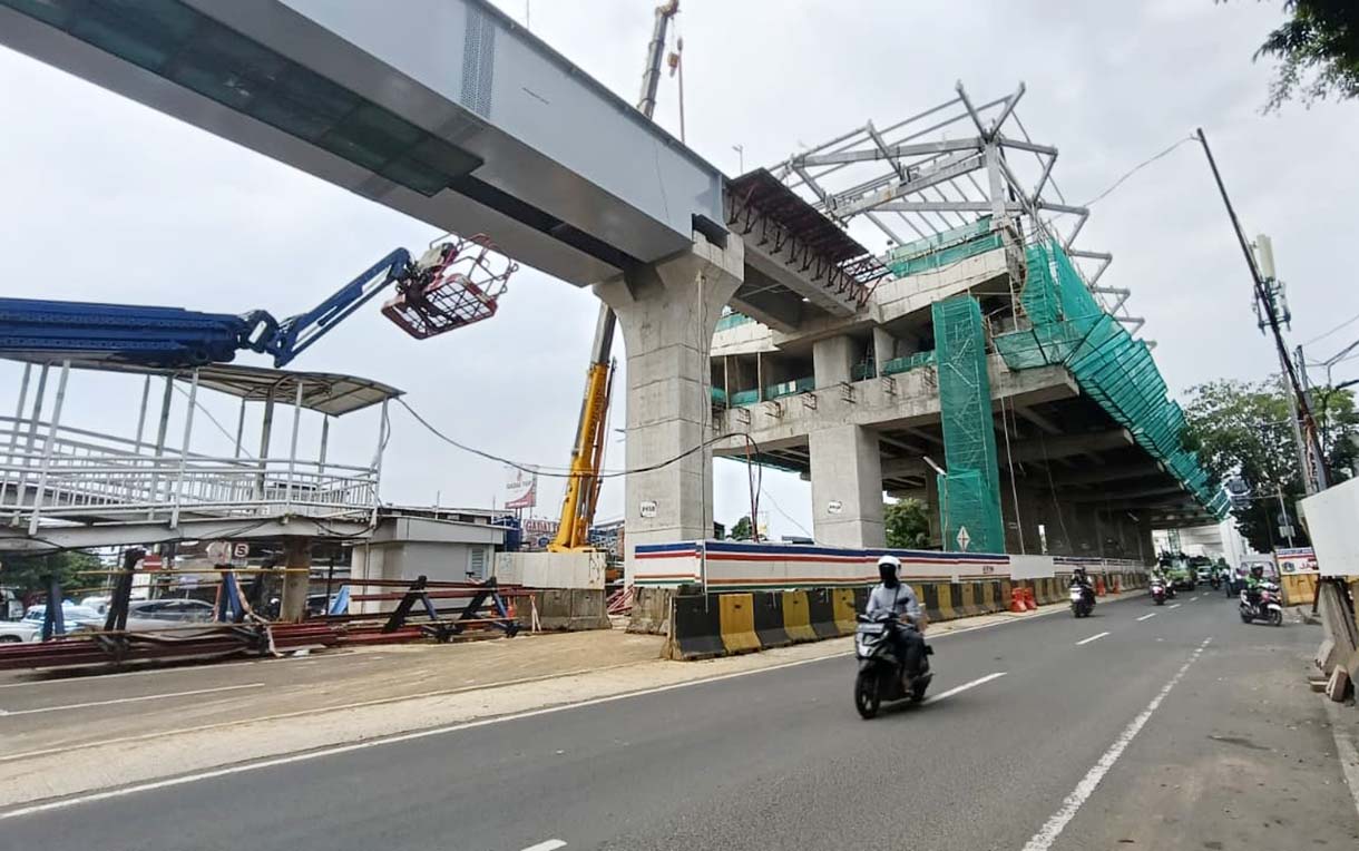 Kendaraan melintas di dekat proyek pembangunan jalur LRT Jakarta Fase 1B yang akan tersambung di atas Jalan Layang Pemuda, Jakarta, Senin (24/11/2025).  (Beritanasional.com/Oke Atmaja)
