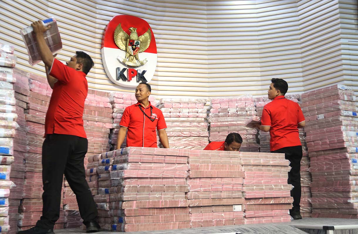 Petugas memindakan uang yang merupakan barang rampasan negara saat acara penyerahan barang rampasan negara dari KPK kepada PT TASPEN di Gedung Merah Putih KPK, Jakarta, Kamis (20/11/2025).  (Beritanasional.com/Oke Atmaja)