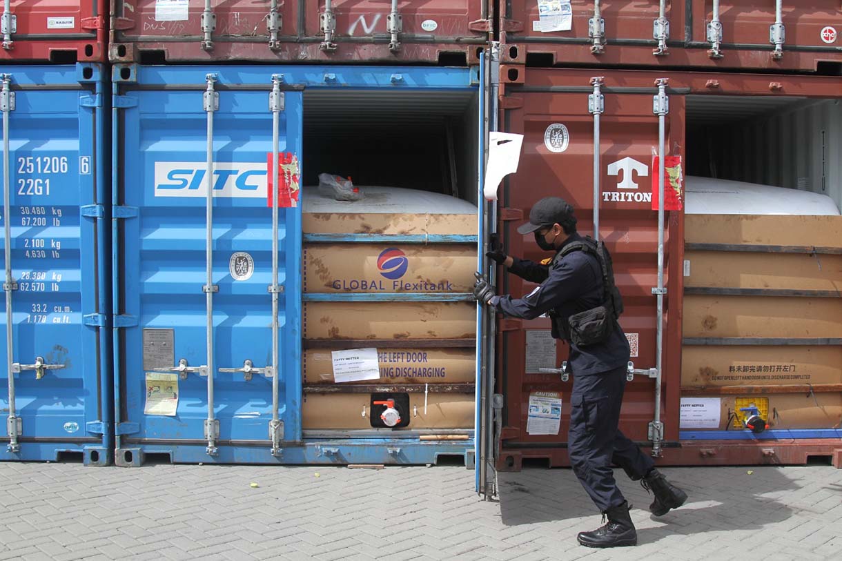 Petugas Bea Cukai menutup pintu kontainer berisi produk turunan minyak sawit mentah atau crude palm oil (CPO) pada konferensi pers penindakan produk yang melanggar aturan ekspor di Jakarta Utara, Kamis (6/11/2025). (Beritanasional.com/Oke Atmaja)