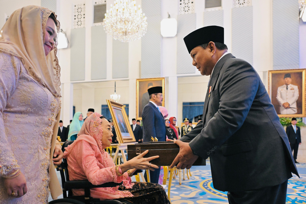Presiden Prabowo Subianto menyalami Istri almarhum K.H. Abdurrahman Wahid, Sinta Nuriyah (kedua kiri) dan anaknya Yenny Wahid (kiri) saat penganugerahan gelar pahlawan nasional di Istana Negara, Jakarta, Senin (10/11/2025).  (Biropers)