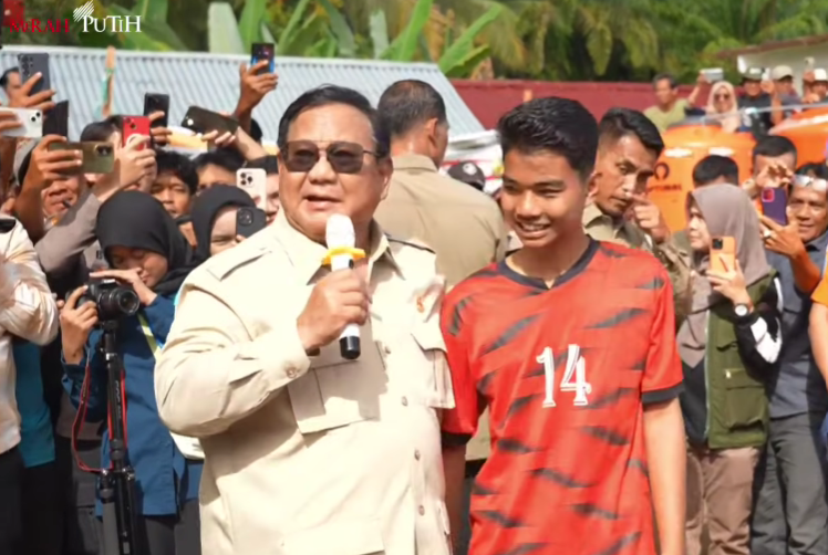 Presiden Prabowo Subianto (kiri) berbincang dengan seorang anak (baju merah) pengungsi di Agam, Sumbar. (Foto/YouTube Setpres)