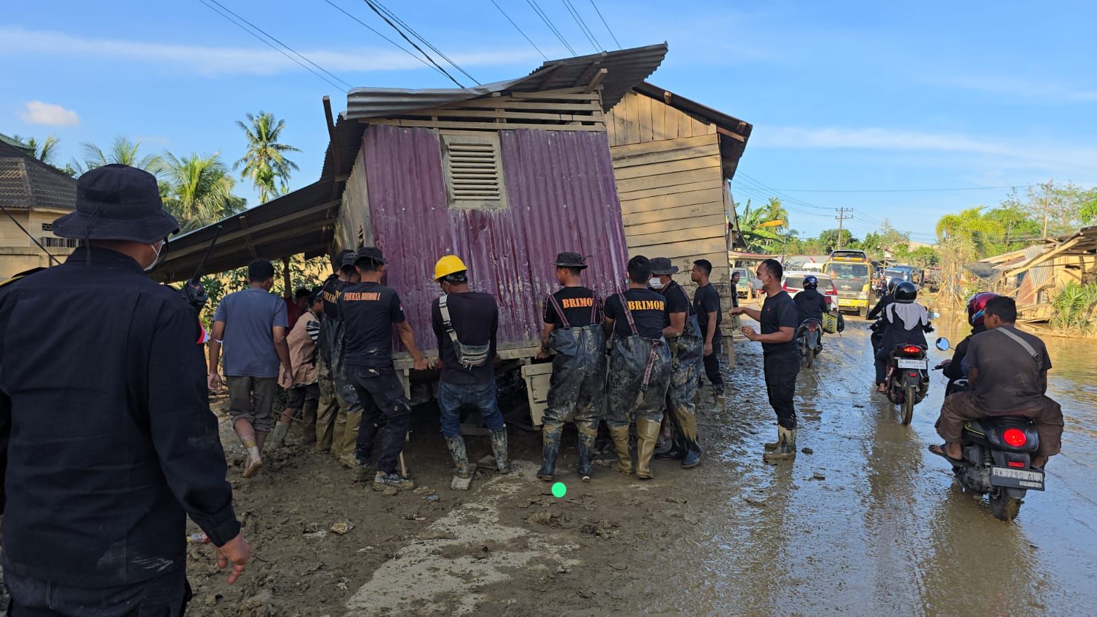 Anggota Brimob Polda Aceh bersama pindahkan rumah yang terbawa banjir bandang. (BeritaNasional/dok Polri)