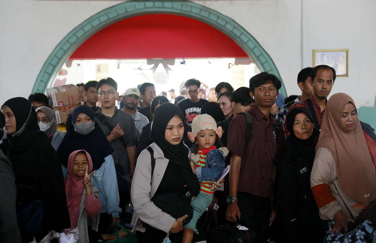 Sejumlah calon penumpang kereta mengantre untuk memasuki peron di Stasiun Pasar Senen, Jakarta, Selasa (23/12/2025).  (Beritanasional.com/Oke Atmaja)